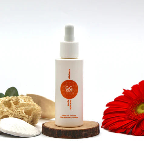Aceite reparador oncológico de GGCare en frasco con cuentagotas sobre superficie natural